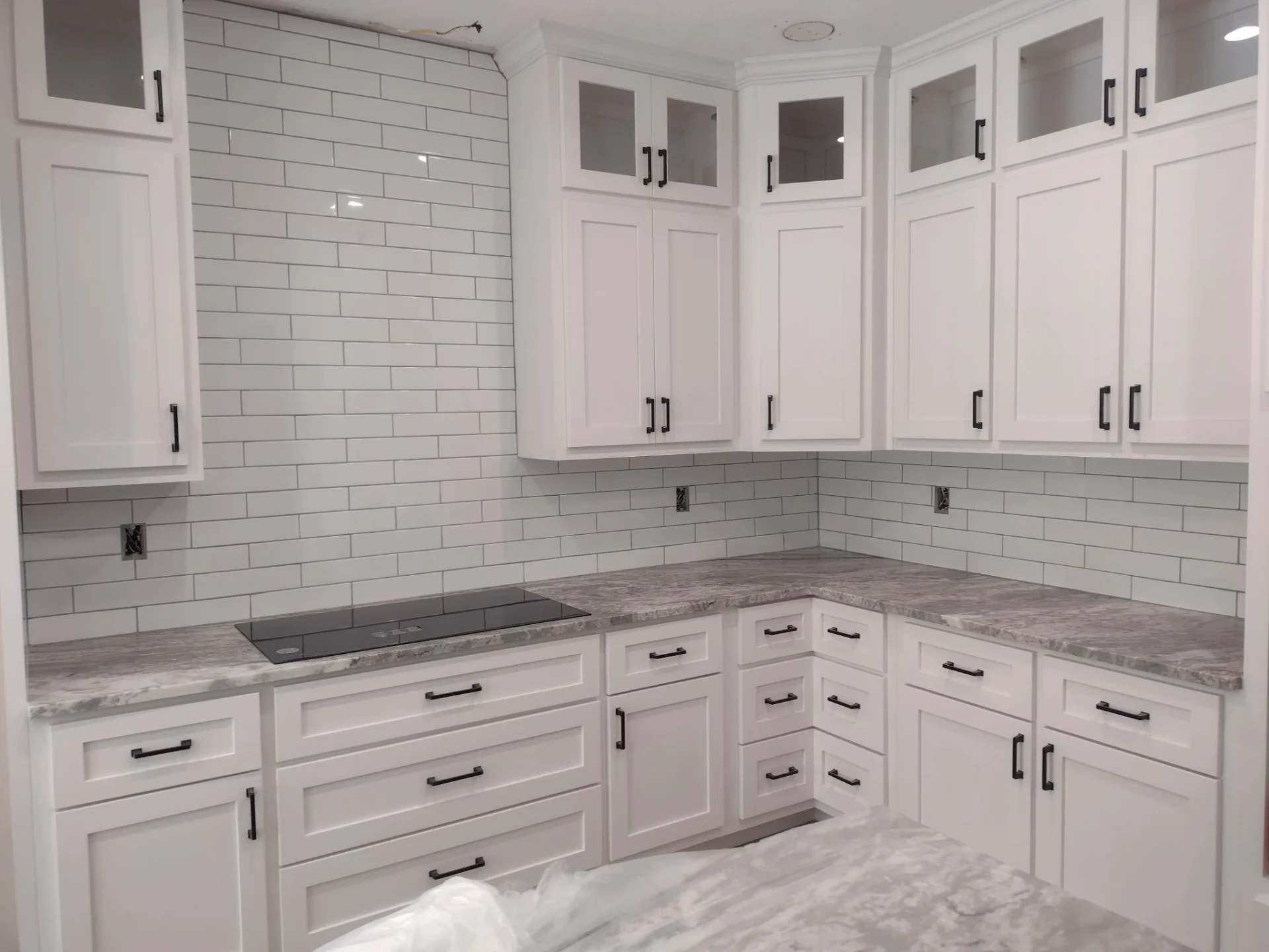 Kitchen remodel with white shaker cabinets, subway tile backsplash and stone countertops